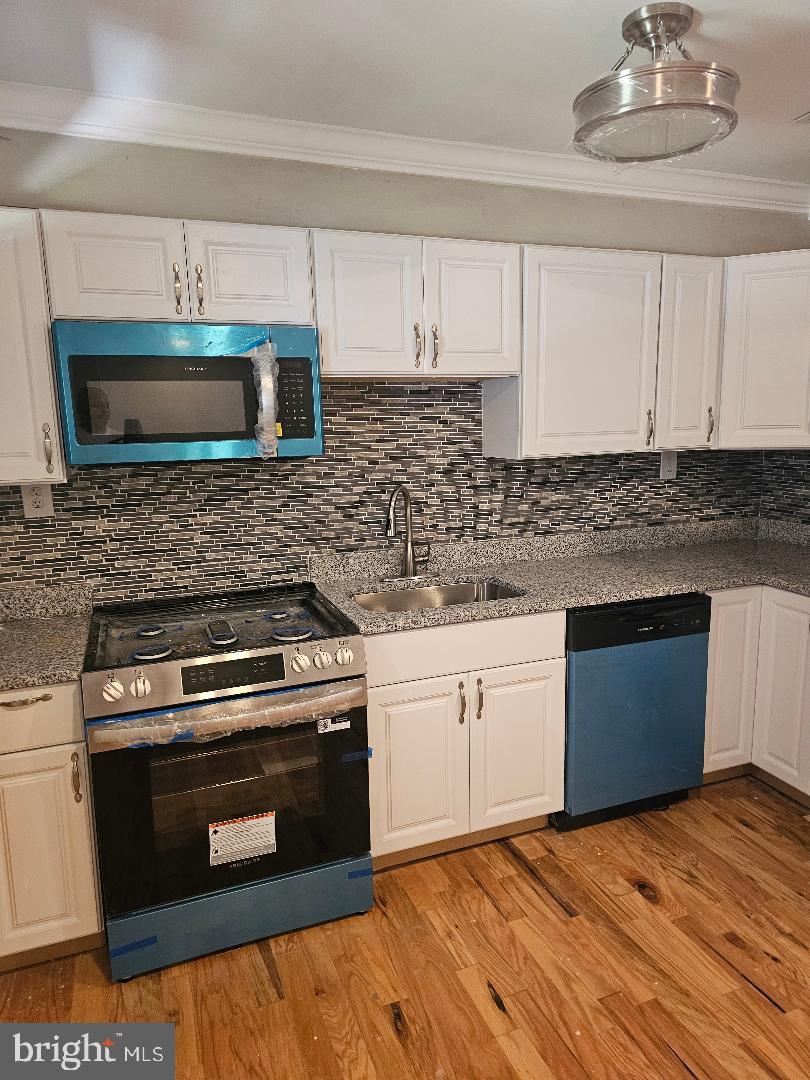 506 Allendale Street Baltimore, MD 21229 - Photo 7 of 27 a kitchen with granite countertop a stove a microwave and cabinets