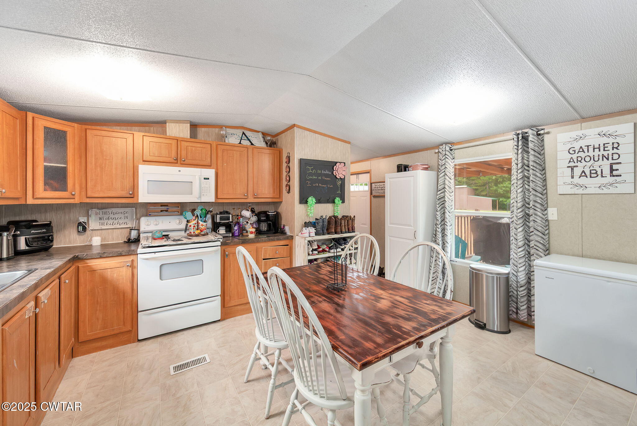 955 Leo Weaver Road Finger, TN 38334 - Photo 5 of 29 a kitchen with a table chairs refrigerator and cabinets