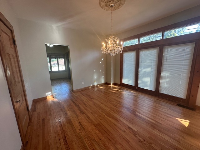 230 Comstock Street, Unit 1 Joliet, IL 60436 - Photo 7 of 20 a view of an empty room with wooden floor and a window
