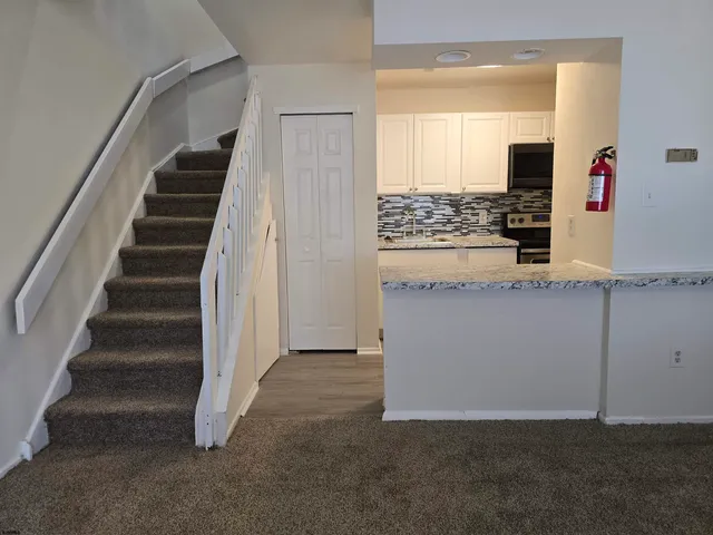 a kitchen with white cabinets and black appliances