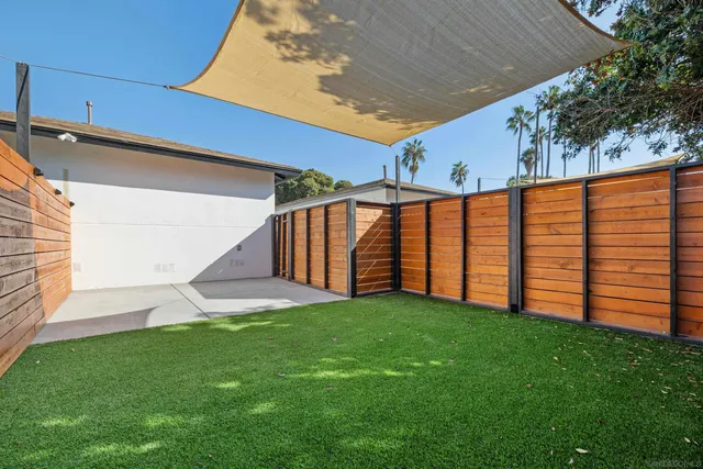 a view of a backyard with wooden fence