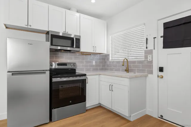 a kitchen with cabinets stainless steel appliances and sink