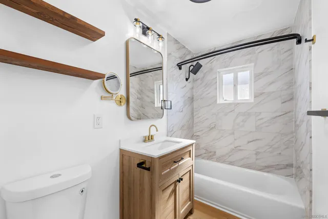 a bathroom with a sink mirror vanity and toilet