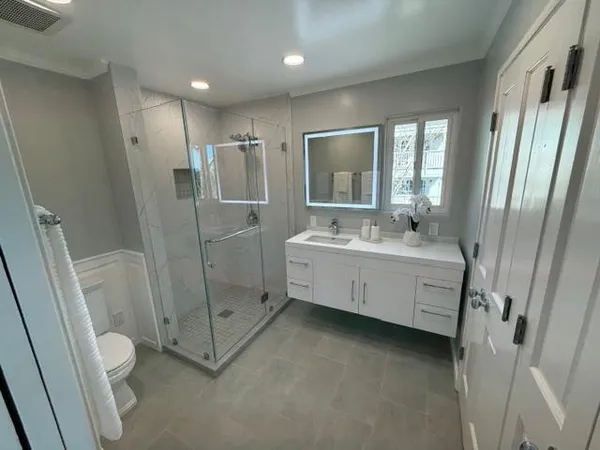 a bathroom with a double vanity sink toilet and shower