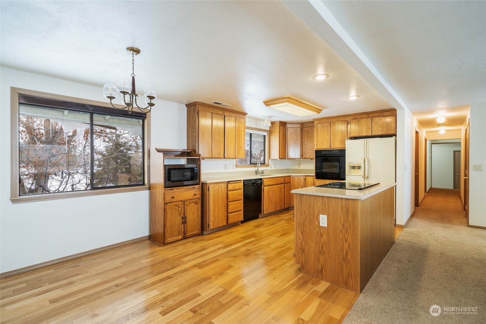 141 Johnson Creek Road Omak, WA 98841 - Photo 14 of 40 a large kitchen with stainless steel appliances granite countertop a stove a sink dishwasher a refrigerator and a dining table with wooden floor