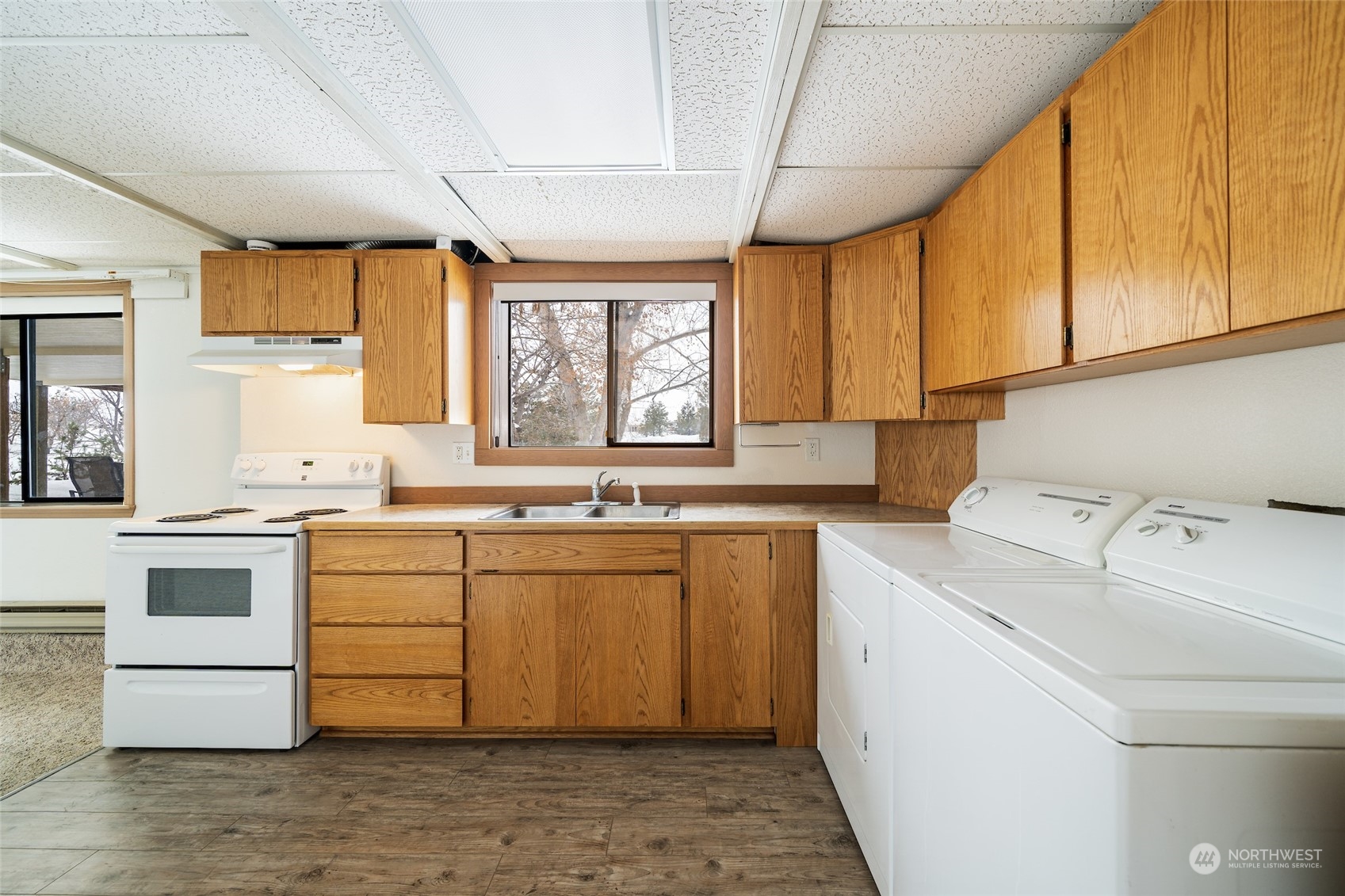 141 Johnson Creek Road Omak, WA 98841 - Photo 30 of 40 a kitchen with a stove a sink and white cabinets with wooden floor