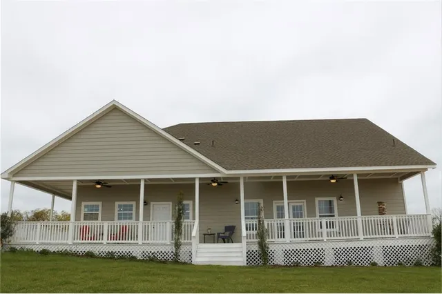 a view of a house with a yard and potted plants