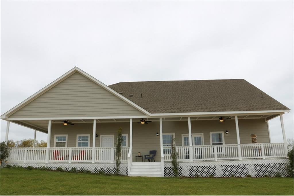 a view of a house with a yard and potted plants
