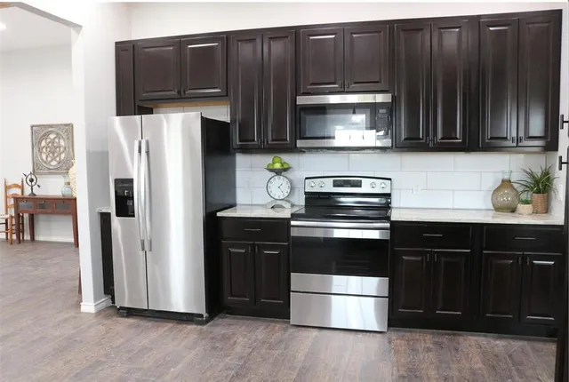 a kitchen with granite countertop wooden cabinets and stainless steel appliances