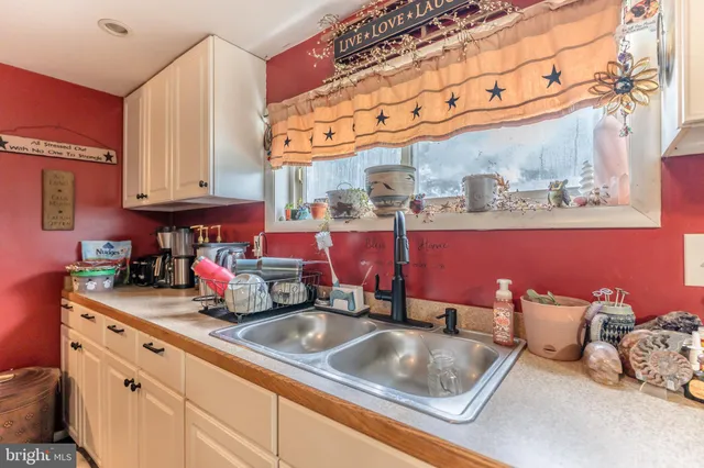 a kitchen with granite countertop lots of clutter and stainless steel appliances