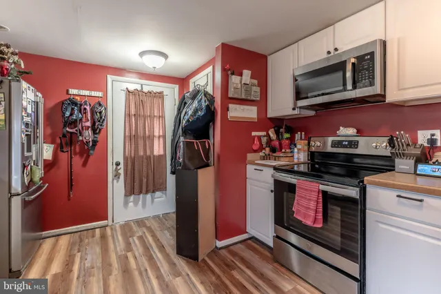 a kitchen with stainless steel appliances granite countertop a stove top oven a refrigerator and a microwave