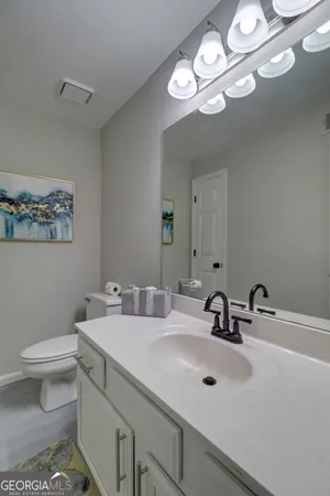 a bathroom with a sink a toilet and a mirror