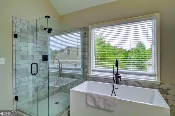 a bathroom with a bath tub and shower