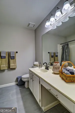 a bathroom with a sink a toilet and a mirror