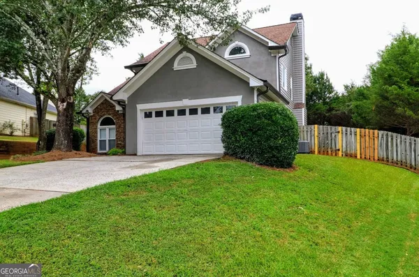 a house with green field in front of it