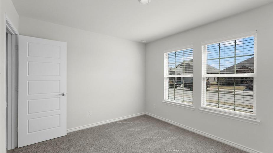 439 Epiphany Lane Lavon, TX 75166 - Photo 25 of 31 Light-filled room featuring two windows with horizontal blinds, gray carpeting, white walls, and a five-panel interior door
