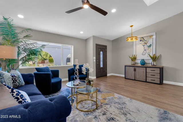 a living room with furniture potted plant and wooden floor
