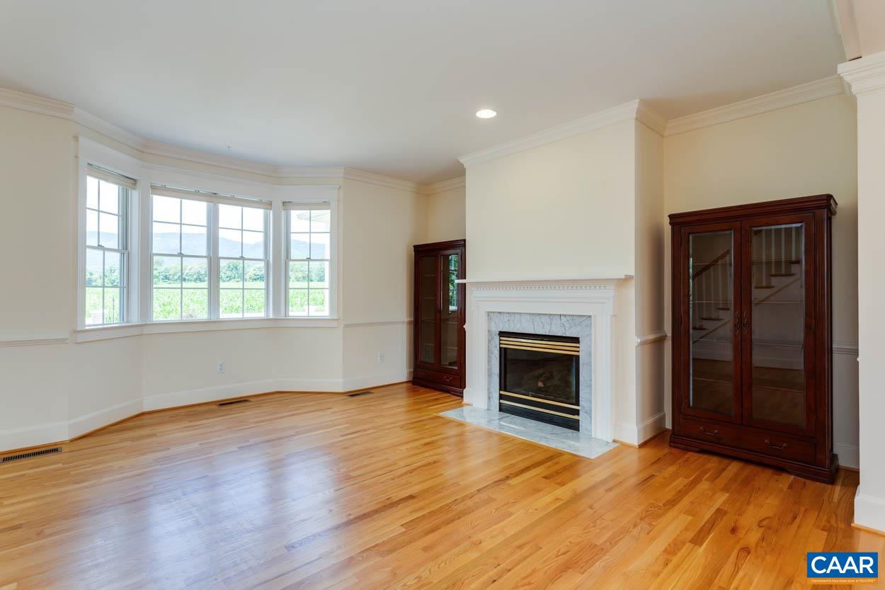 1904 Beaver Ridge Road Crozet, VA 22932 - Photo 16 of 70 an empty room with wooden floor fireplace and windows