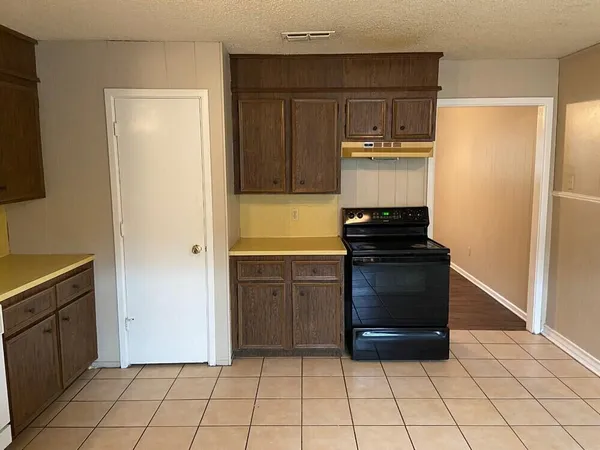 a kitchen with a refrigerator and a stove top oven