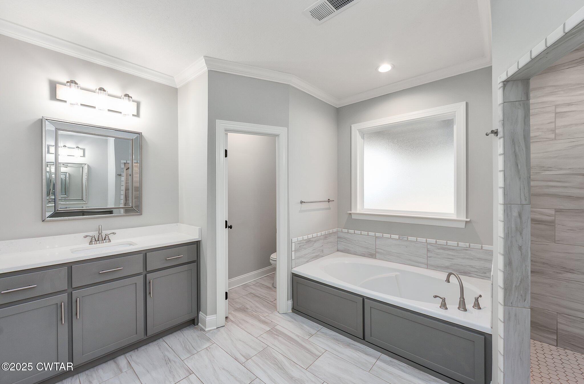 42 Lancaster Cove Jackson, TN 38305 - Photo 14 of 44 a bathroom with a tub a sink and mirror