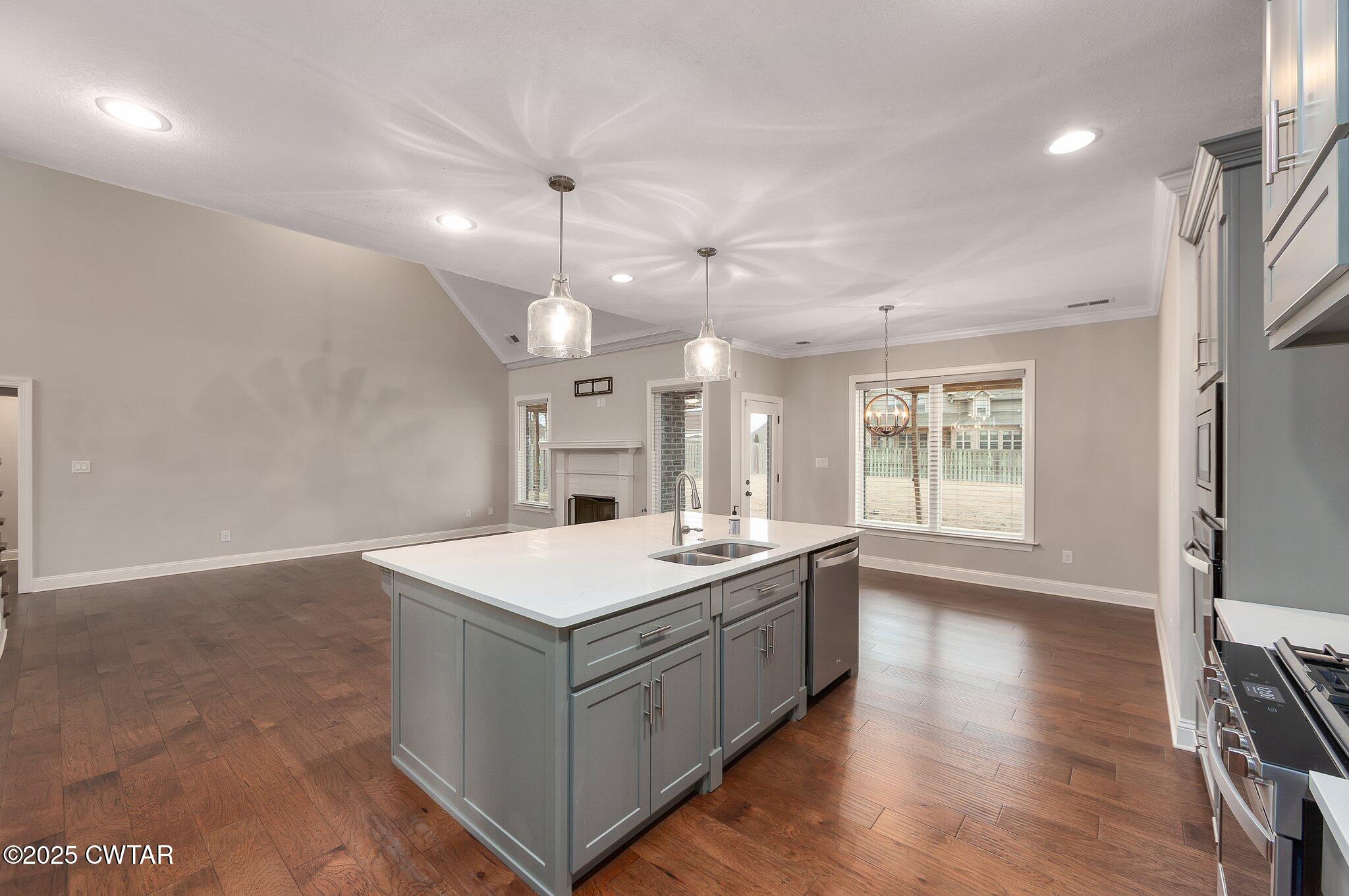 42 Lancaster Cove Jackson, TN 38305 - Photo 23 of 44 a large white kitchen with a stove a sink dishwasher and a refrigerator with wooden floor