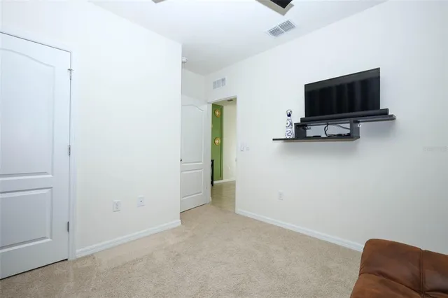 an empty room with a window and a fan