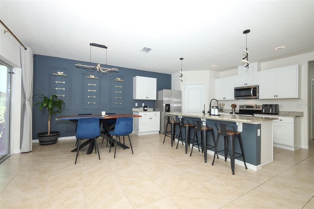 33417 Affirmed Way Sorrento, FL 32776 - Photo 5 of 43 a kitchen with a dining table chairs and white appliances