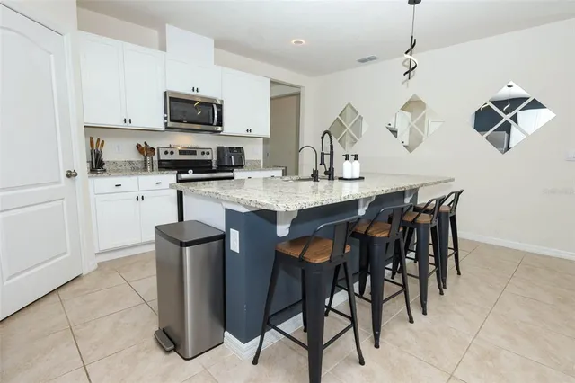 a kitchen with stainless steel appliances granite countertop a sink a stove and a refrigerator