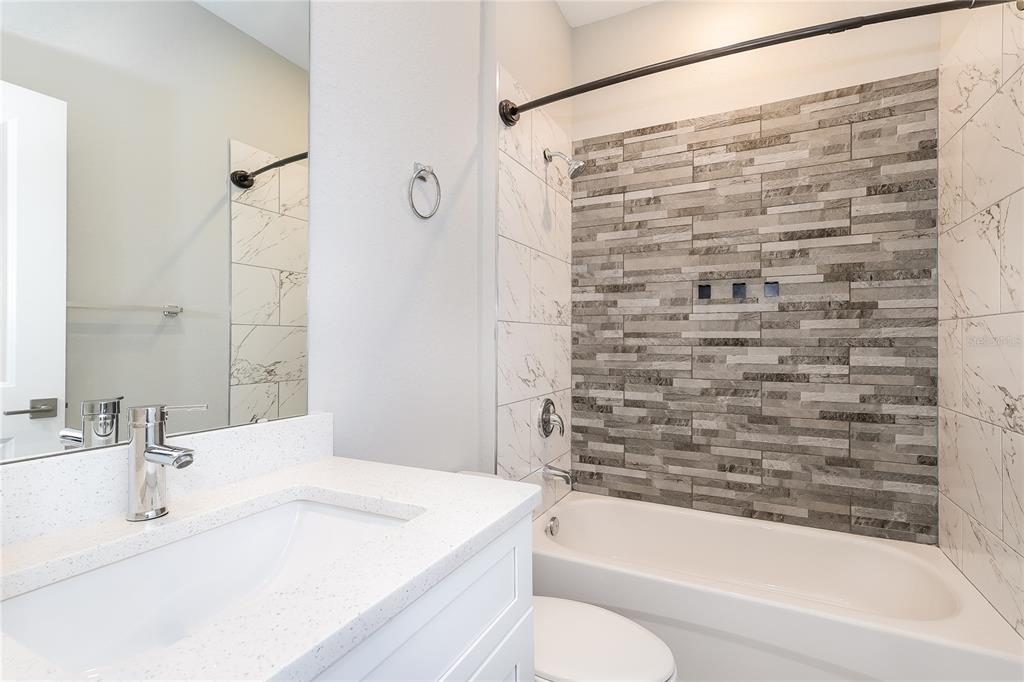 2177 Rio Grande Canyon Loop Kissimmee, FL 34759 - Photo 13 of 15 a bathroom with a granite countertop bathtub shower sink vanity and toilet