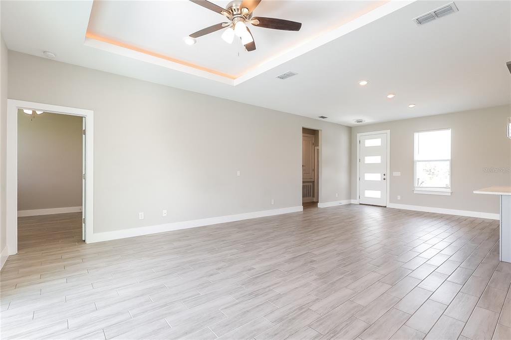 2177 Rio Grande Canyon Loop Kissimmee, FL 34759 - Photo 2 of 15 an empty room with wooden floor fan and windows