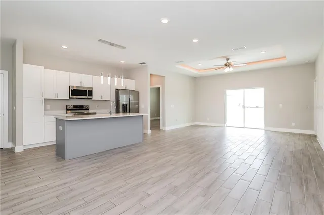 a large kitchen with stainless steel appliances granite countertop a stove a sink and a refrigerator