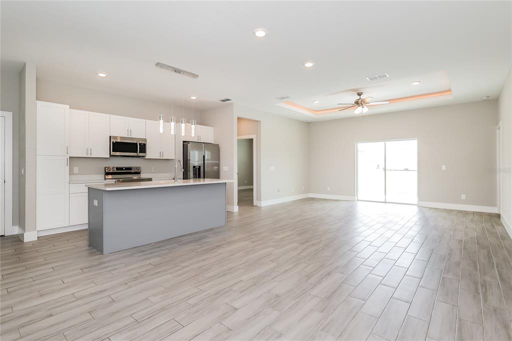 2177 Rio Grande Canyon Loop Kissimmee, FL 34759 - Photo 5 of 15 a large kitchen with stainless steel appliances granite countertop a stove a sink and a refrigerator