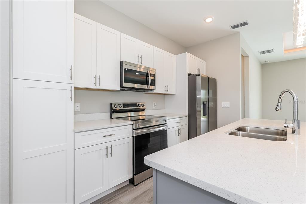 2177 Rio Grande Canyon Loop Kissimmee, FL 34759 - Photo 6 of 15 a kitchen with stainless steel appliances a refrigerator stove microwave and sink