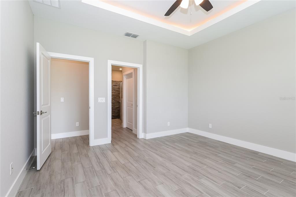 2177 Rio Grande Canyon Loop Kissimmee, FL 34759 - Photo 7 of 15 an empty room with wooden floor and chandelier fan