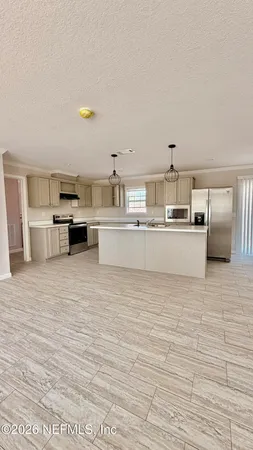 a large white kitchen with stainless steel appliances granite countertop a stove and a wooden floors