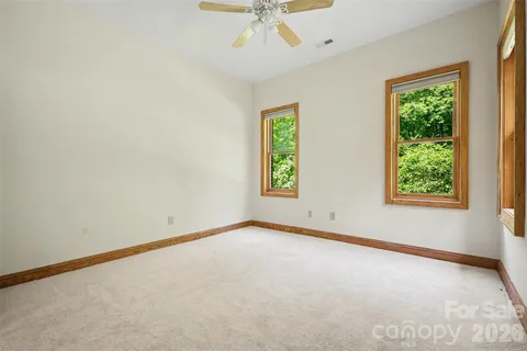 an empty room with a window and a fan