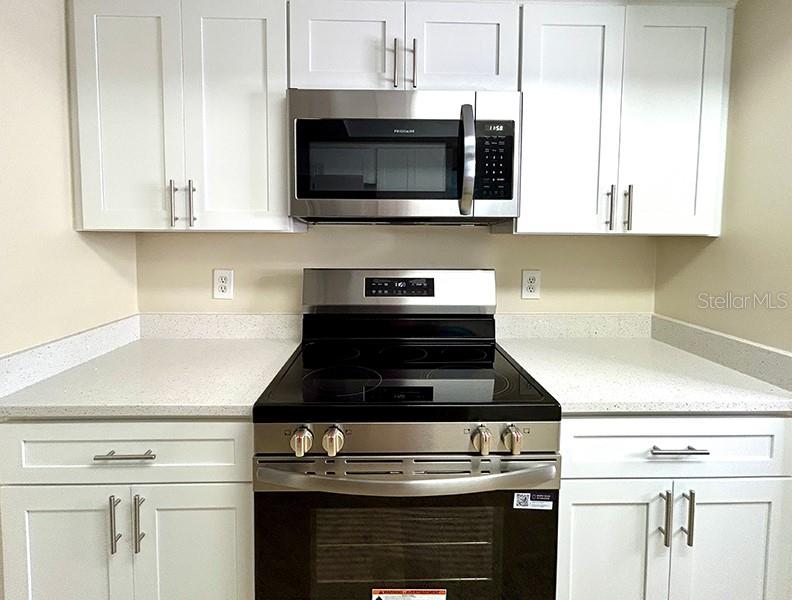 4791 Deer Road Orlando, FL 32812 - Photo 11 of 35 a kitchen with stainless steel appliances granite countertop white cabinets and black stove top oven with granite countertops