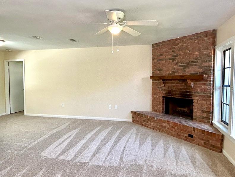4791 Deer Road Orlando, FL 32812 - Photo 7 of 35 a view of a livingroom with a fireplace a ceiling fan and window