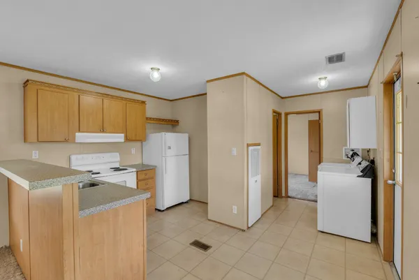 a view of a kitchen with refrigerator and a stove