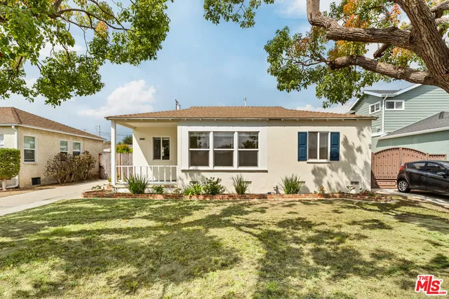 a front view of a house with a garden and yard