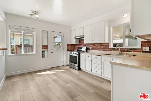 a kitchen with granite countertop a stove sink and cabinets