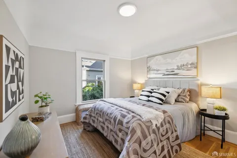 a bedroom with a bed and a painting on the wall