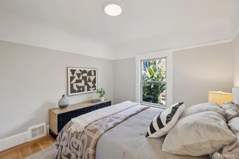 a bedroom with a bed and a painting on the wall