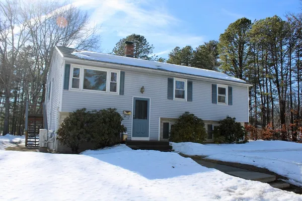 a view of a house with a yard covered with snow in the background