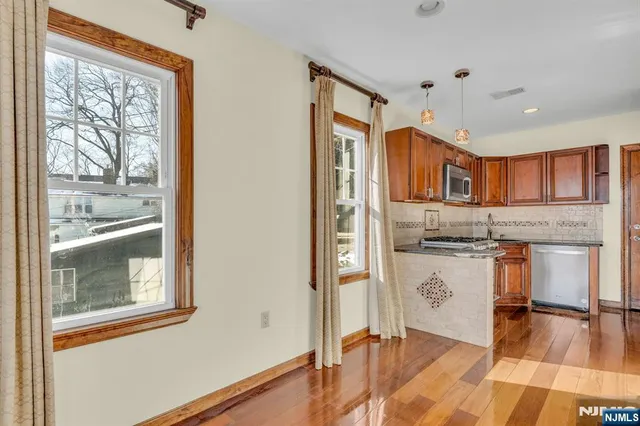 a living room with stainless steel appliances granite countertop furniture and a window