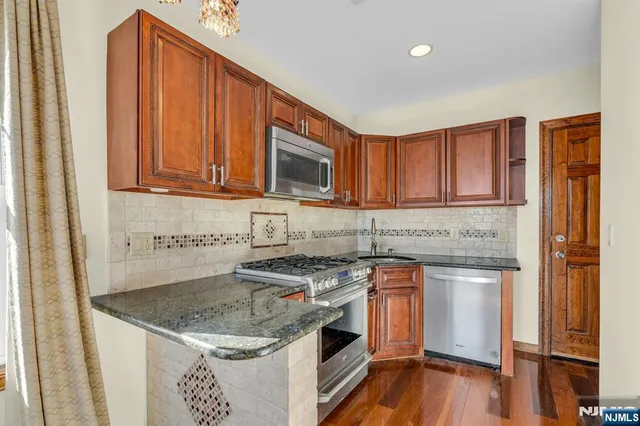 a kitchen with stainless steel appliances granite countertop a sink stove microwave and cabinets