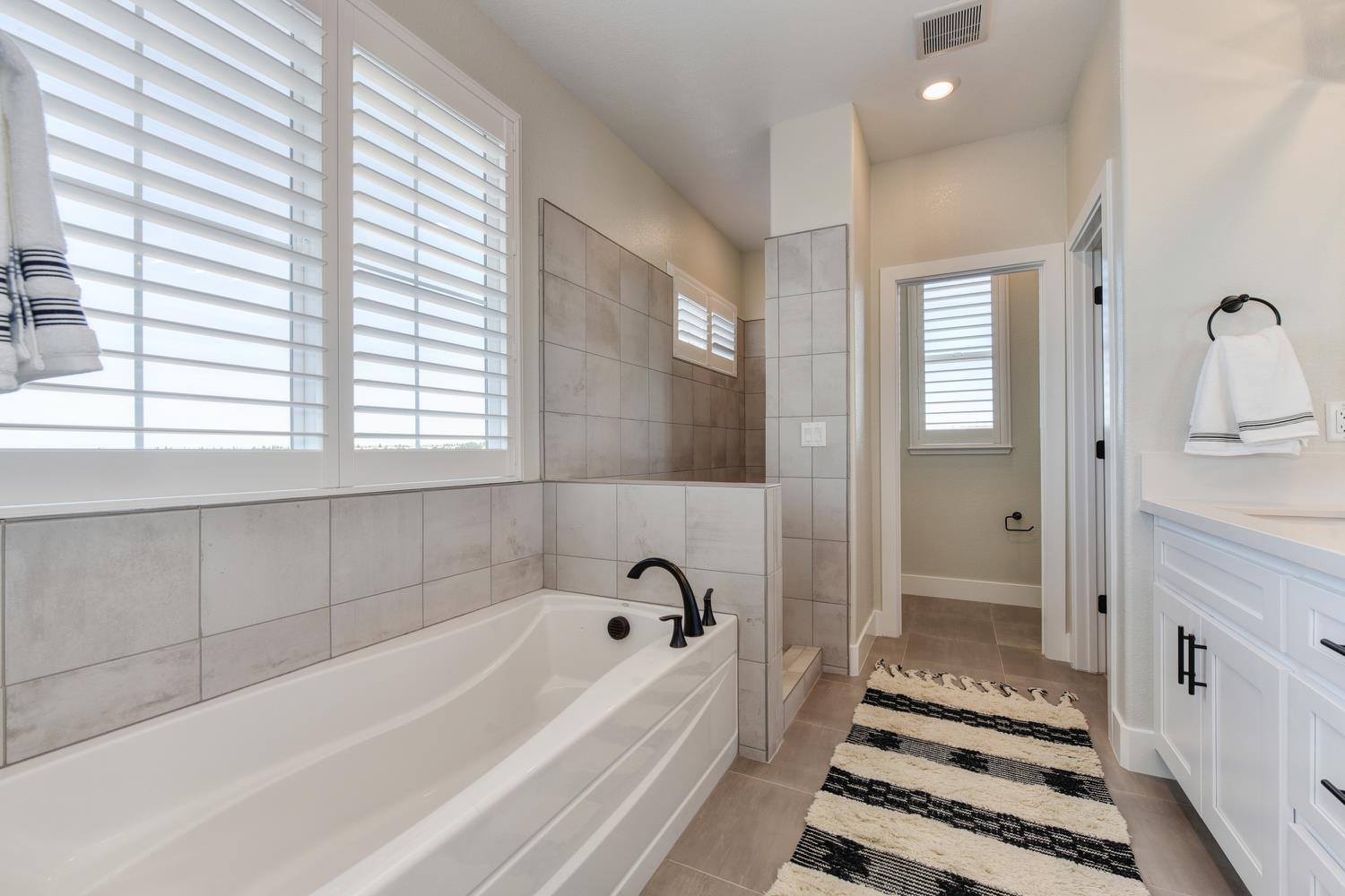 4080 Peter's Court Rocklin, CA 95765 - Photo 49 of 64 a bathroom with a bathtub and a shower
