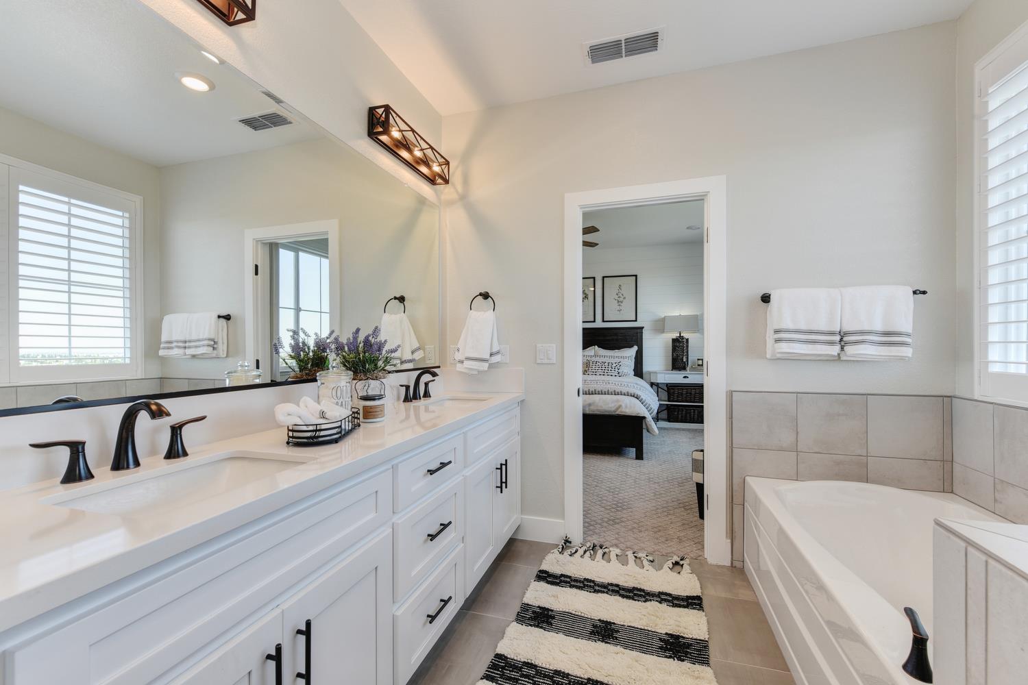 4080 Peter's Court Rocklin, CA 95765 - Photo 51 of 64 a bathroom with a tub sink and mirror