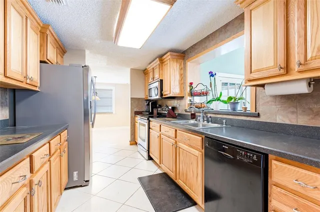 a view of an empty room with furniture and a window