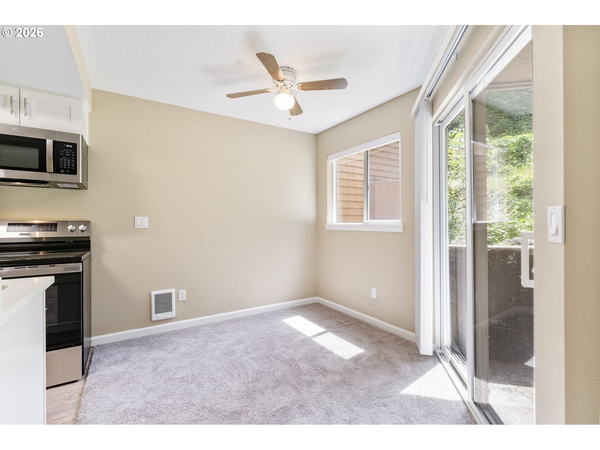 9967 Southeast Talbert Street Clackamas, OR 97015 - Photo 12 of 33 a workspace with wooden floor a ceiling fan and a window